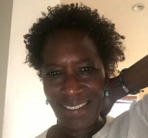 Casting Director Victoria Thomas smiling in her home wearing a white shirt.