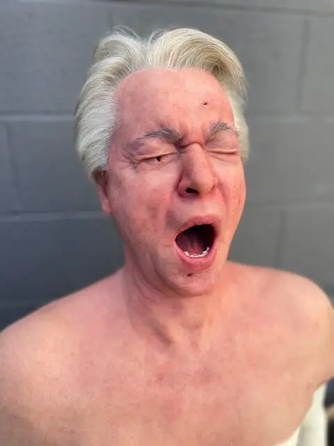 A likeness head of an old man created by a special effects artist for a movie.
