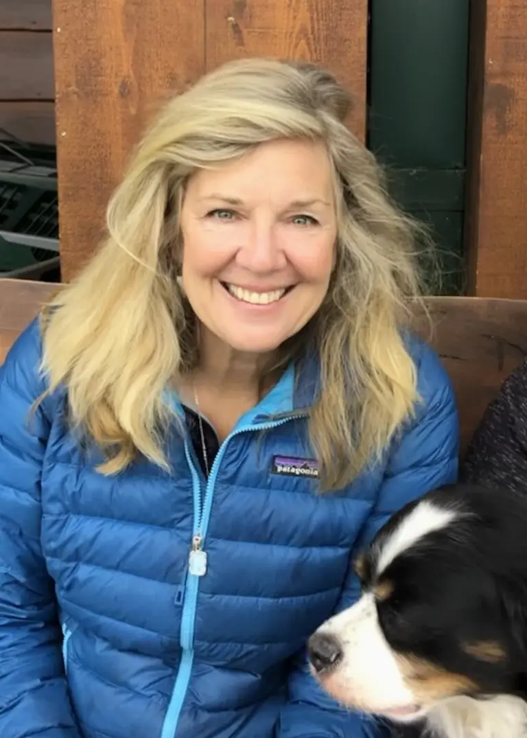 Karen Margaret Cole smiling with her dog outside.