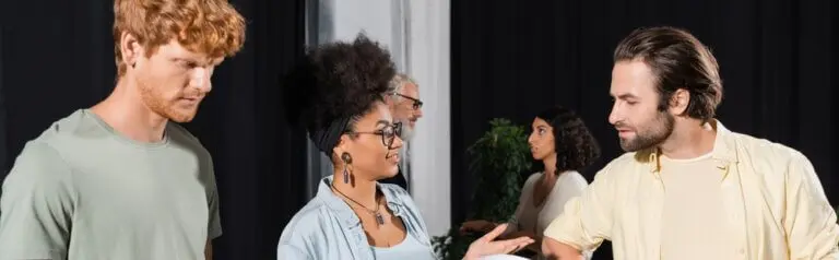 Two actors talking as another one waits to chat.