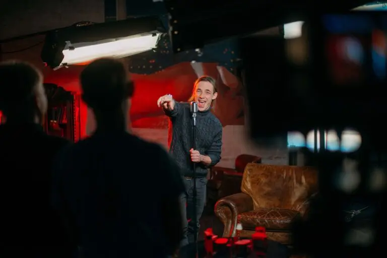 Stand up comedian pointing at a member of the crowd during a set.