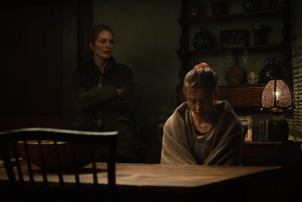 Julianne Moore talking to Syndey Sweeney, who is upset and sitting at a table wrapped in a blanket.