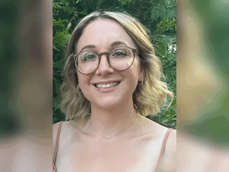 Casting director Jamie Ember smiling outside in a park, surrounded by trees.