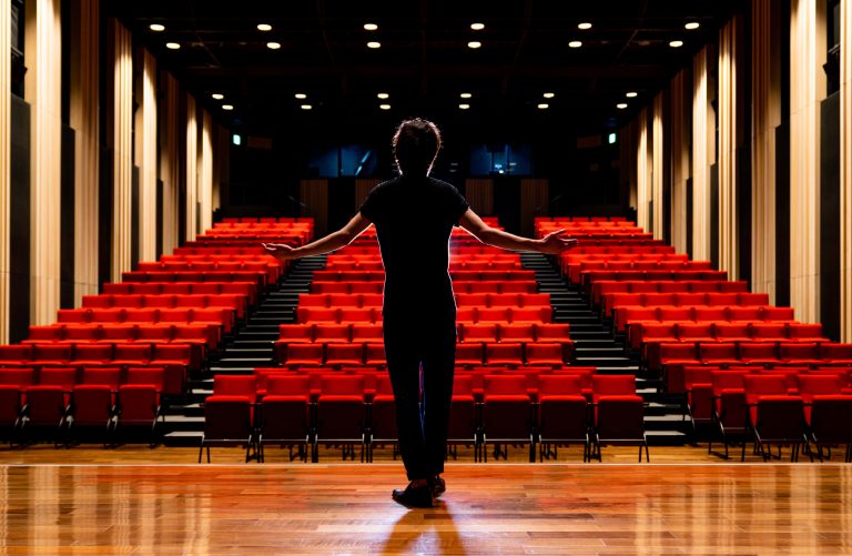 Young actor in a theater before sharing a story about their favorite auditions.