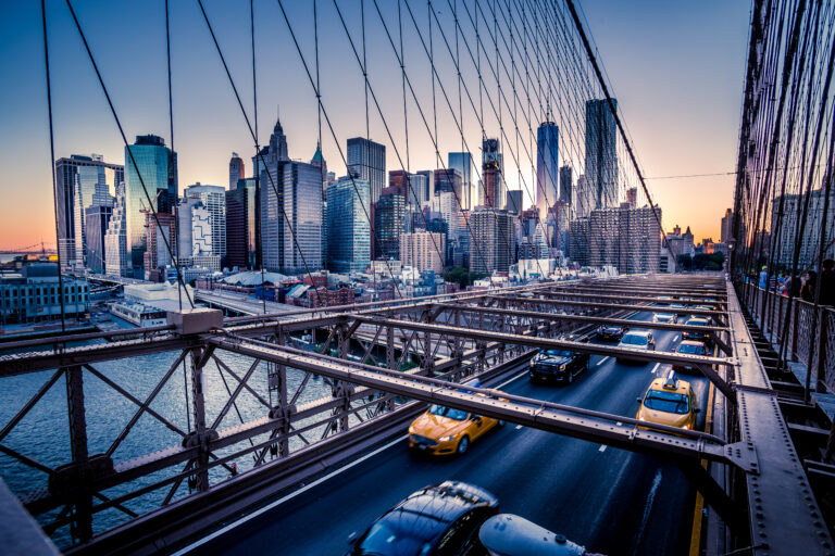 Cars speeding at sunset on Brooklyn Bridge, Manhattan. One of the most iconic bridges in the world, a must see attraction when visiting New York.