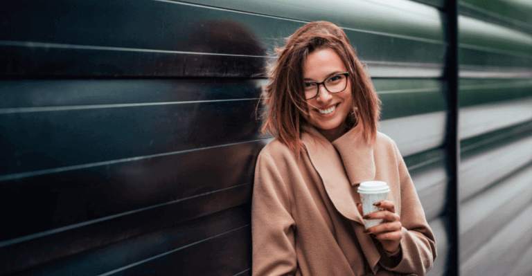 Happy woman holding a cup of coffee