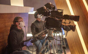 masked cameraman is filming a television show in the studio. TV