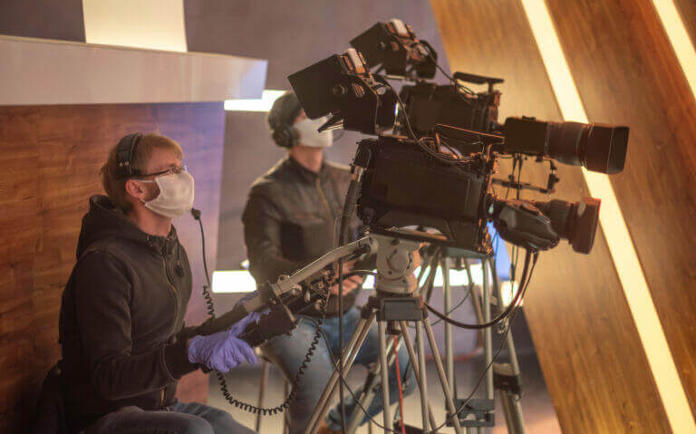 masked cameraman is filming a television show in the studio. TV