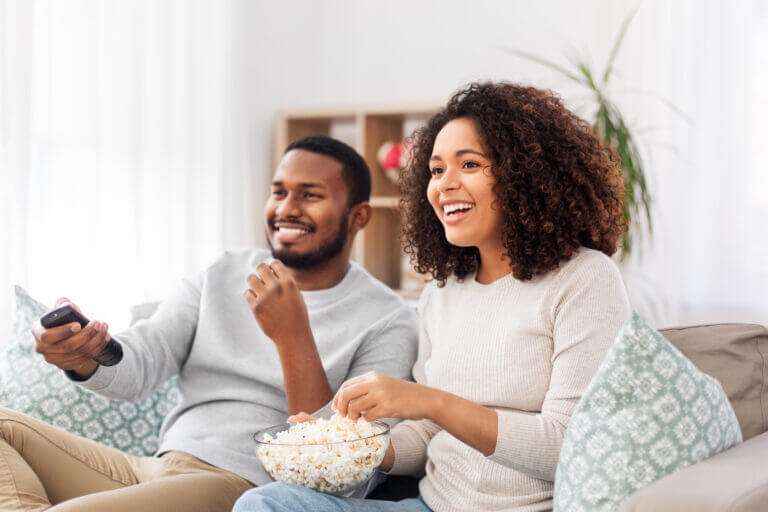 Two actors watching one of the 4 movies streaming in October.