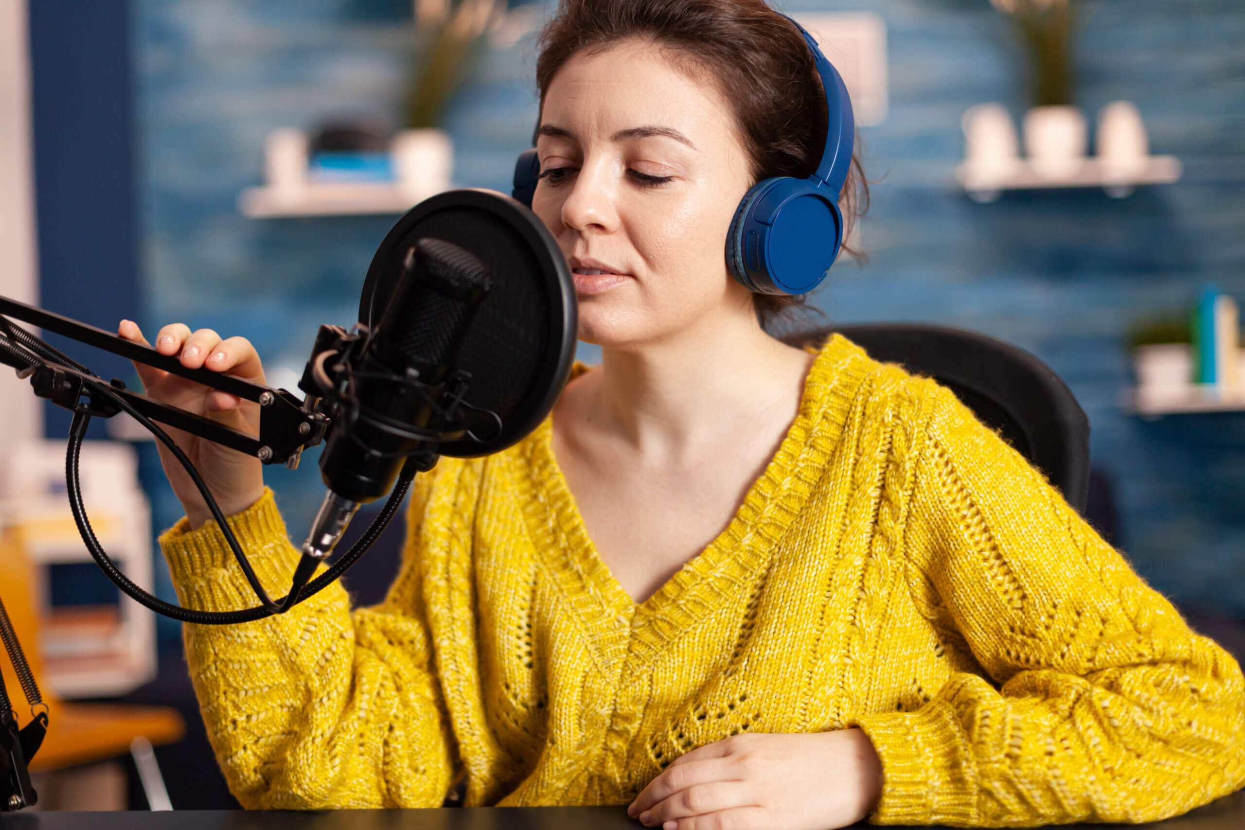 A podcaster recording an episode for her podcast in her studio.