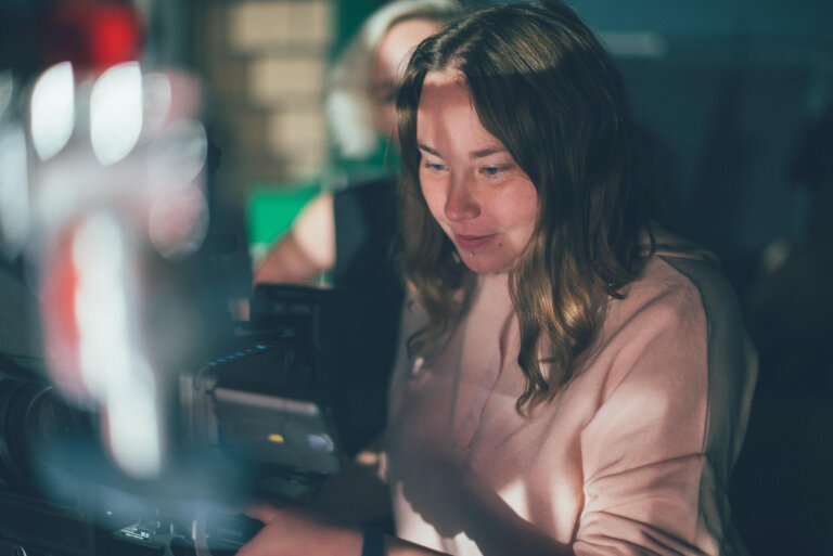 A female film director watches the latest take from behind the camera