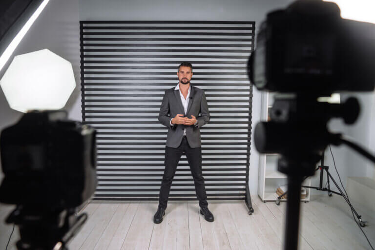 An actor wearing a suit filming a self tape audition in a garage.