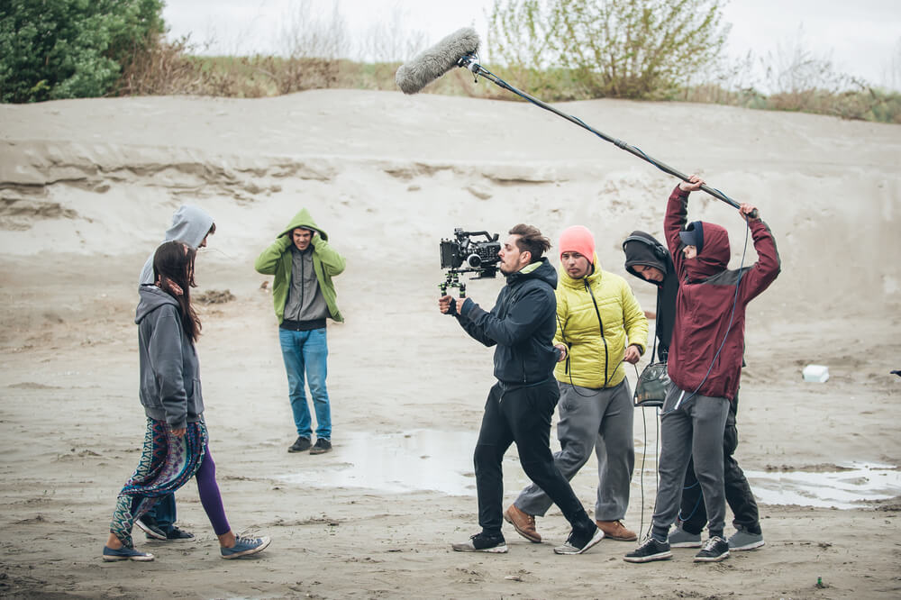 Two actors and a small indie film crew shooting a low budget movie outside.