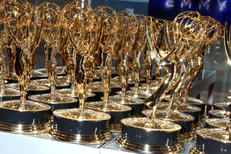 A table set up with dozens of Emmy Award trophies.