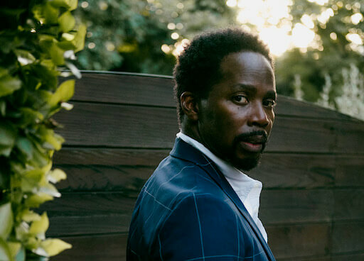 Actor Harold Perrineau wearing a blue suit outside .