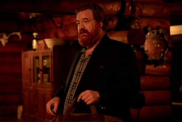Happy Anderson inside wearing a jacket and dress shirt indoors lookign surprised.