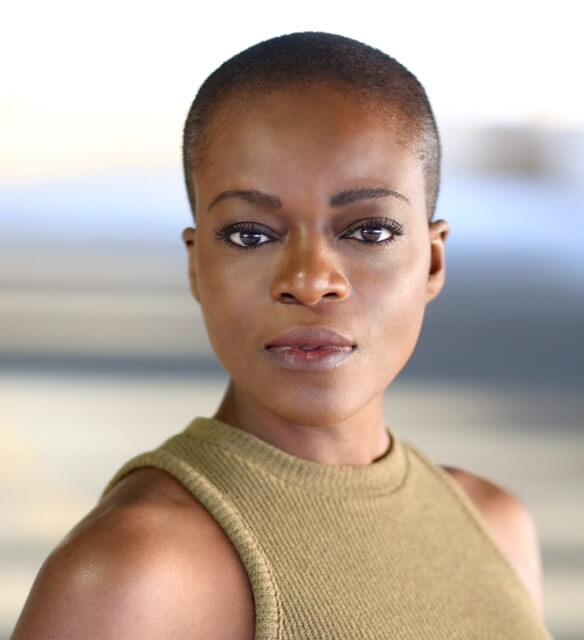 Actor Adeola Role in a green shirt staring confidently.