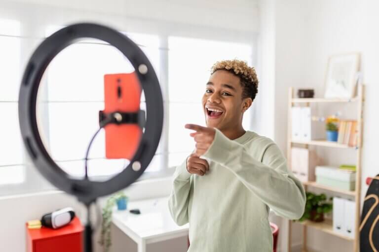 An actor recording a self tape audition at home smiling and pointing at the camera.
