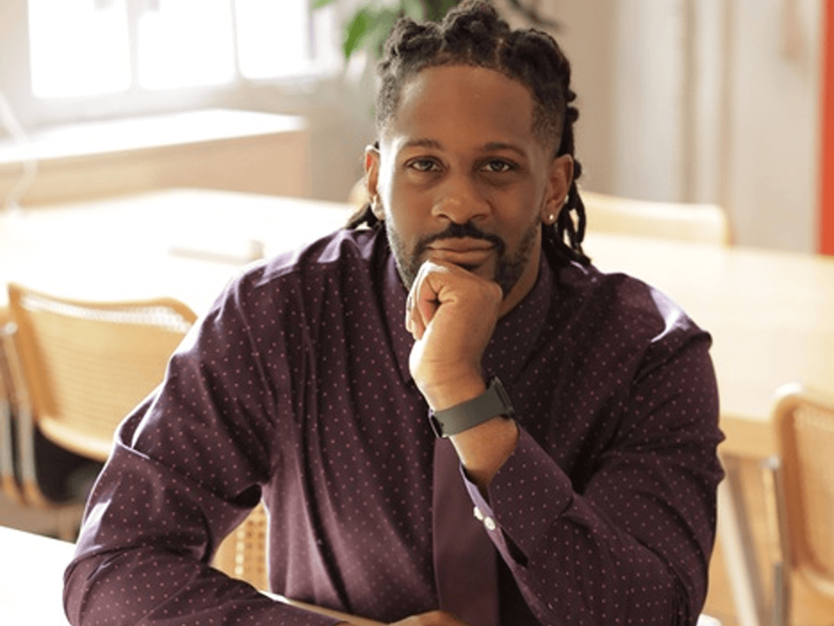 Gregory Omar Osborne sitting at a desk smiling.