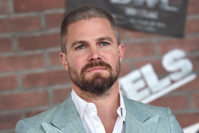 Actor Stephen Amell in a suit looking concerned.