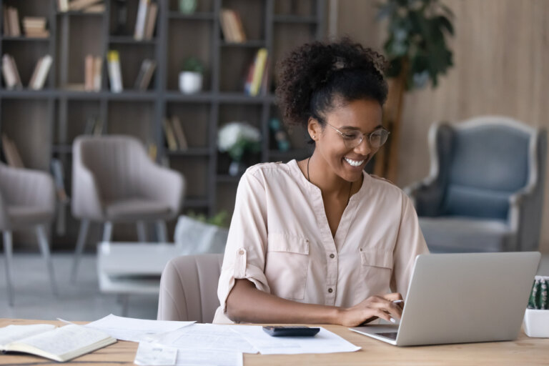 Happy Aftrican American woman working on her laptop at home