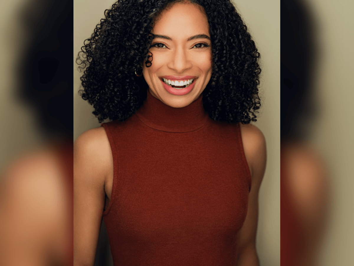 Actor Ashlei Hazell smiling in a sleveless burgundy turtleneck