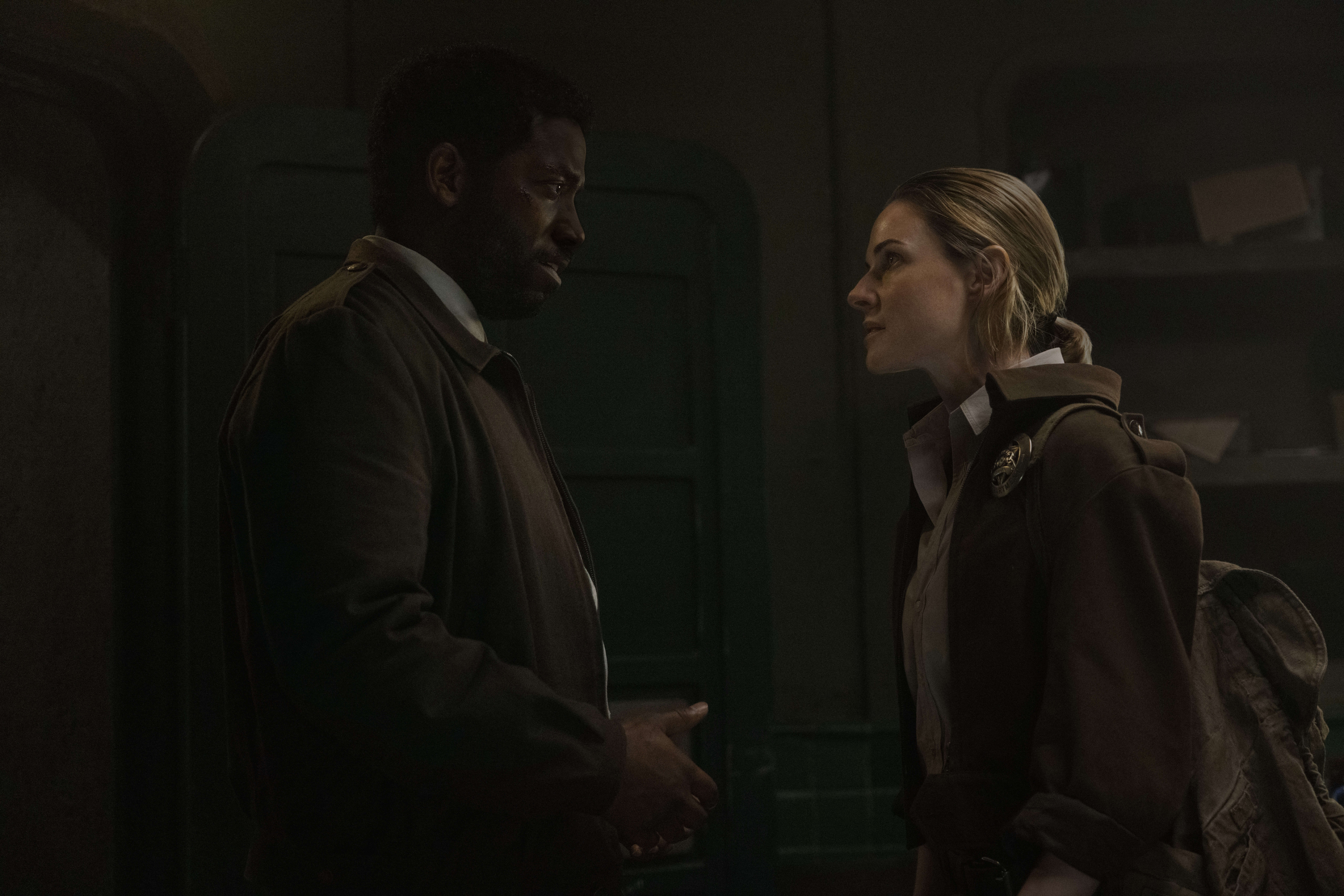 Chinaza Uche and Rebecca Ferguson talking in a small room.