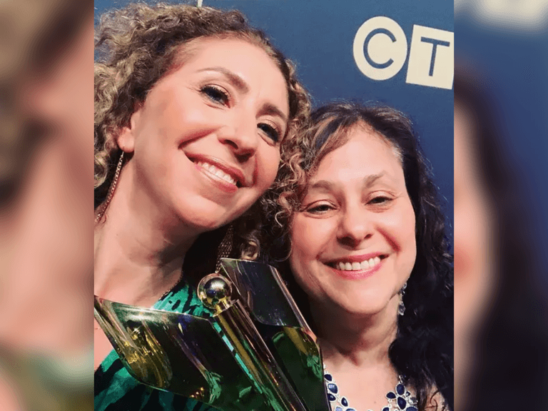 Casting directors Sara Kay and Jenny Lewis smiling and holding an award.