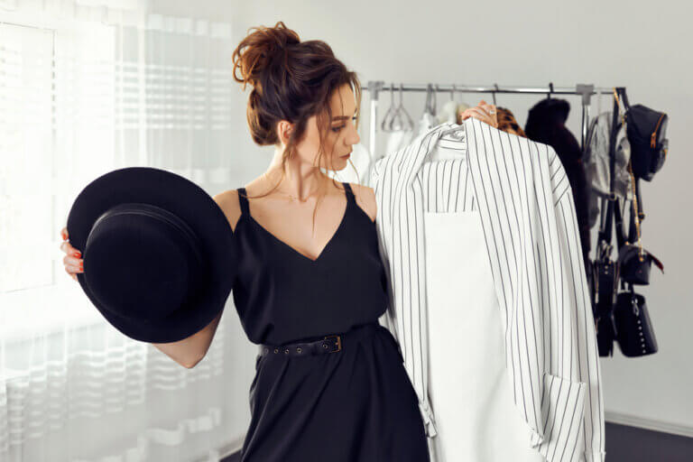 A young woman picking out closthes from her closet to wear to an audition.
