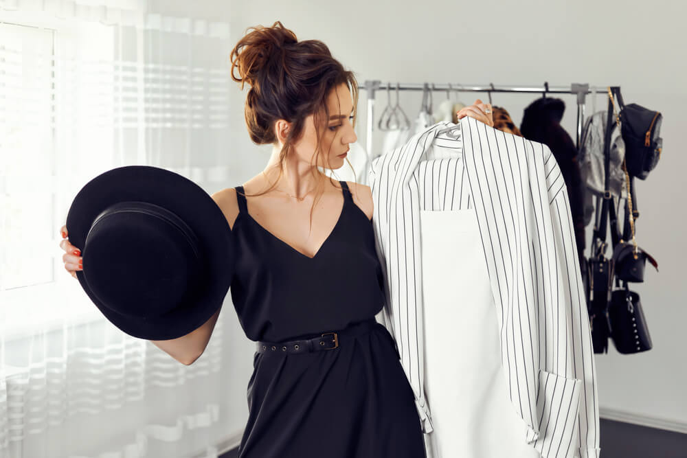 A young woman picking out closthes from her closet to wear to an audition.