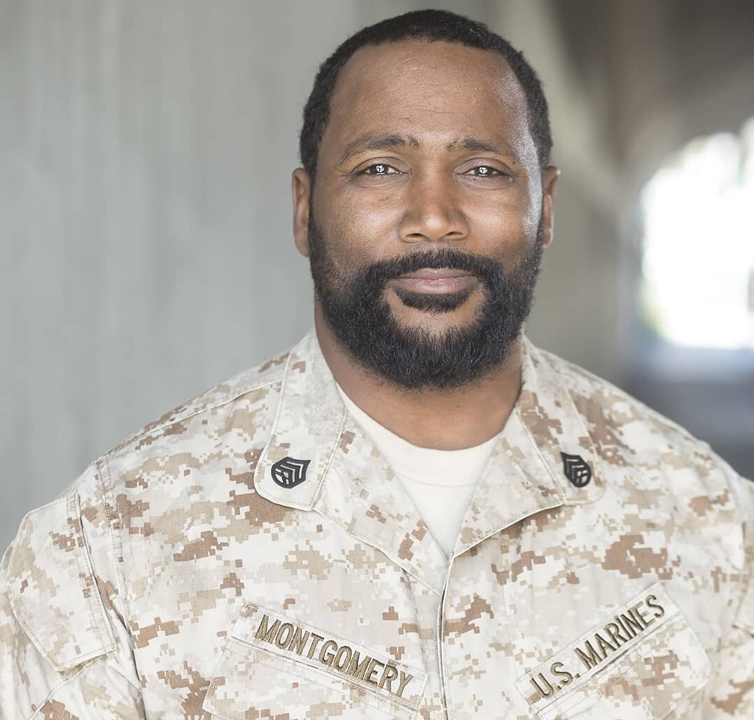 Actor Darius Cottrell in military fatigues smiling.