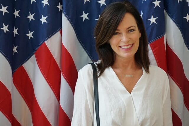 Casting Director Karen Ryan smiling in front of the American flag.