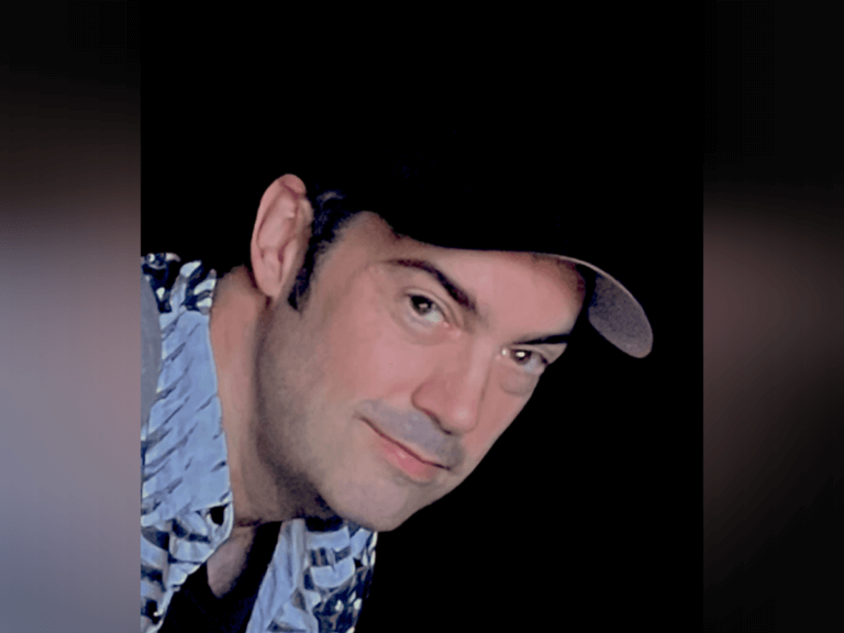 Casting director Mark Bennett wearing a hat and smiling.