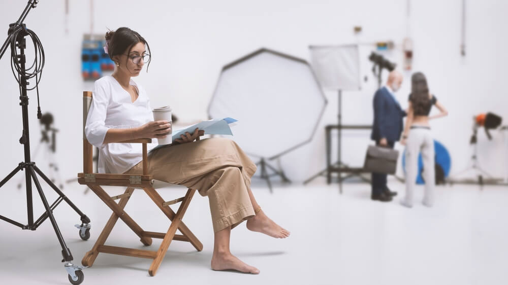Actress reading lines on set, coffee in hand.