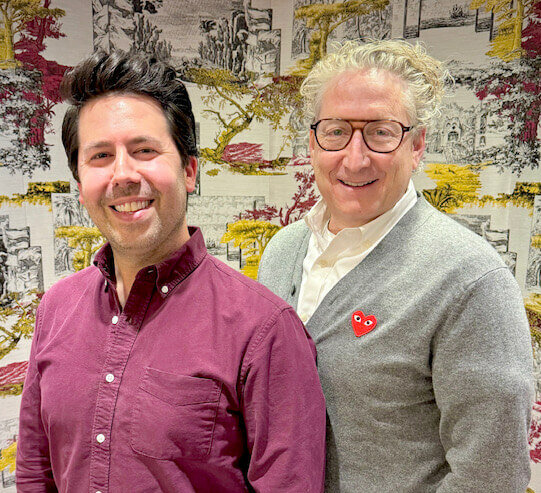 Adam Caldwell (left) and Bernie Telsey (right) smiling at an art gallery.