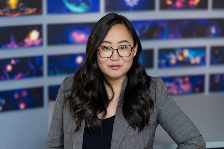 Actor Grace Kim in a suit smiling inside.