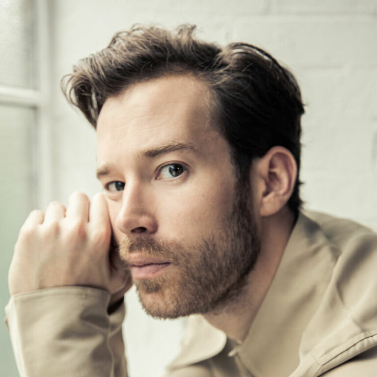 Actor David Shields sitting by a window inside.