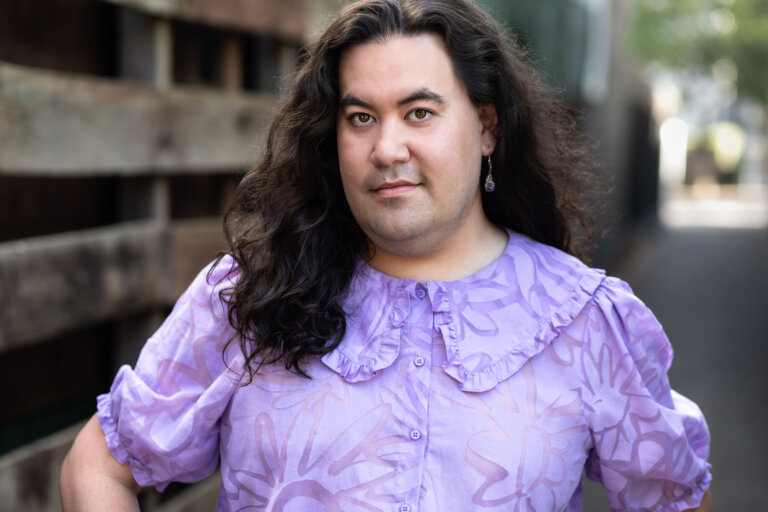 Casting Director Rhys Velasquez outside in a purple shirt.