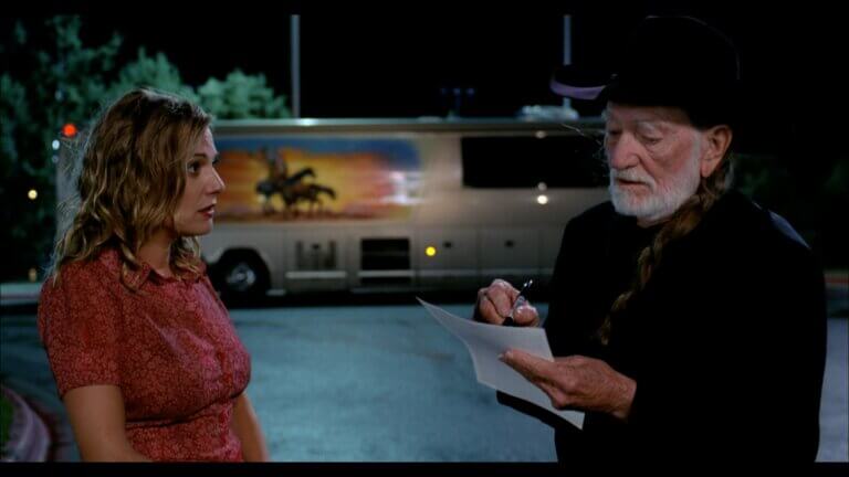 Eva Hassman and Willie Nelson talking outside his tour bus.
