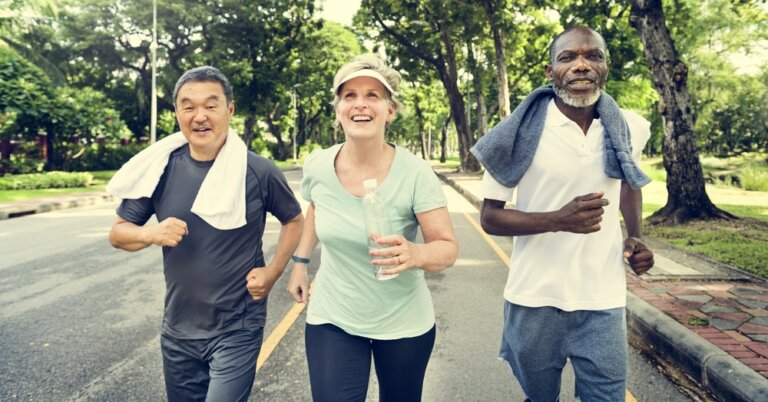 A diverse group of middle aged runners going for a jog in the park.