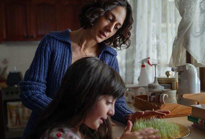 A mother and daughter cooking in the kitchen.