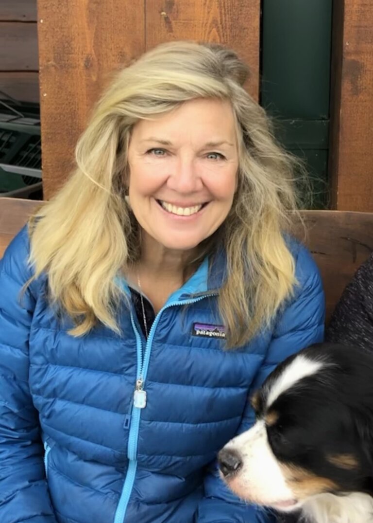 Karen Margaret Cole smiling with her dog outside.