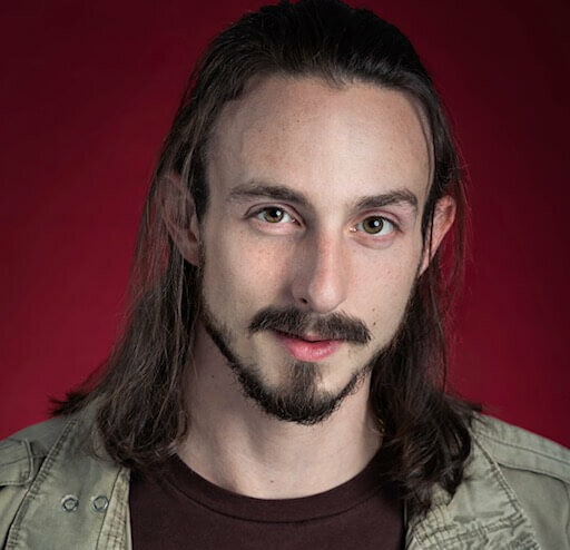 Smiling in front of a red backdrop.