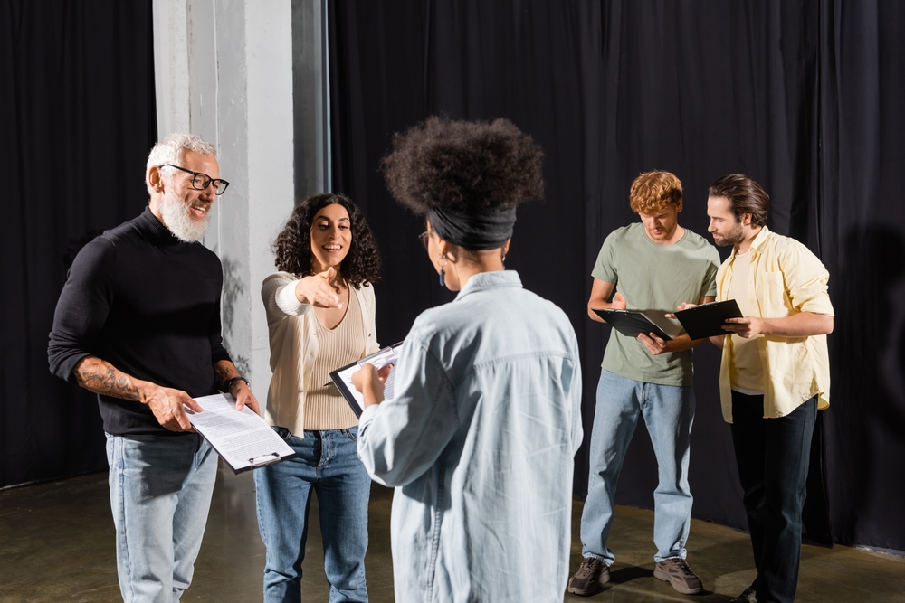 African American woman teaching an acting class with diverse students.