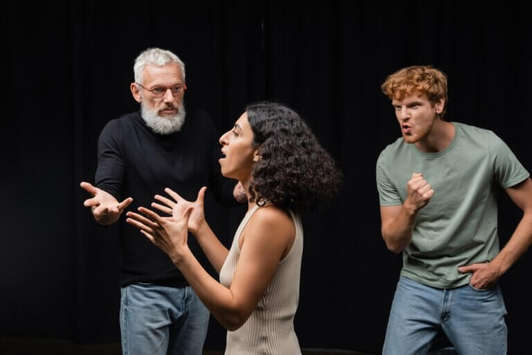 Diverse group of actors rehearsing various emotions backstage.