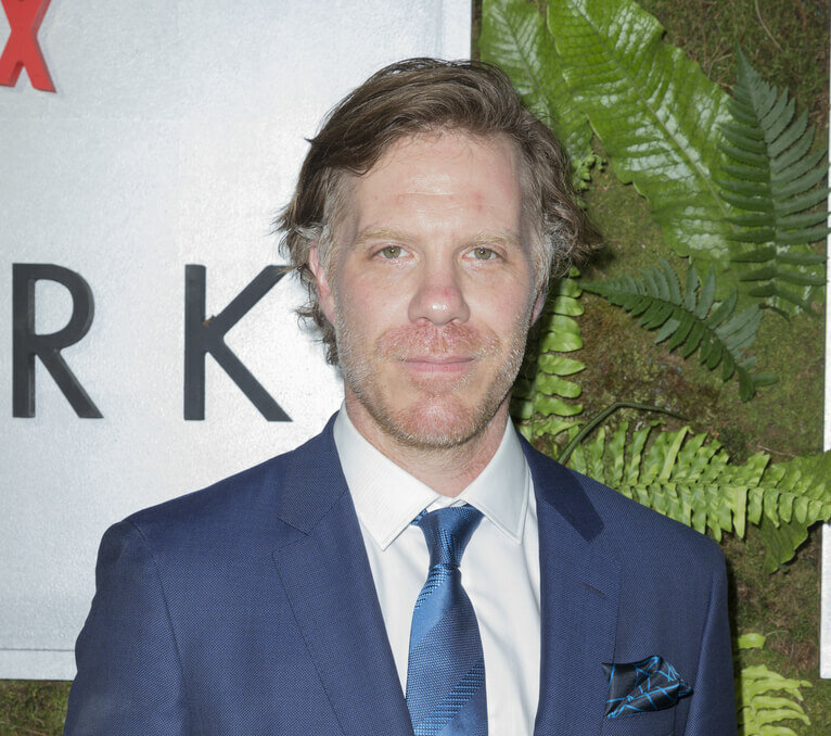 Actor Marc Menchaca in a blue suit at a premiere outside.