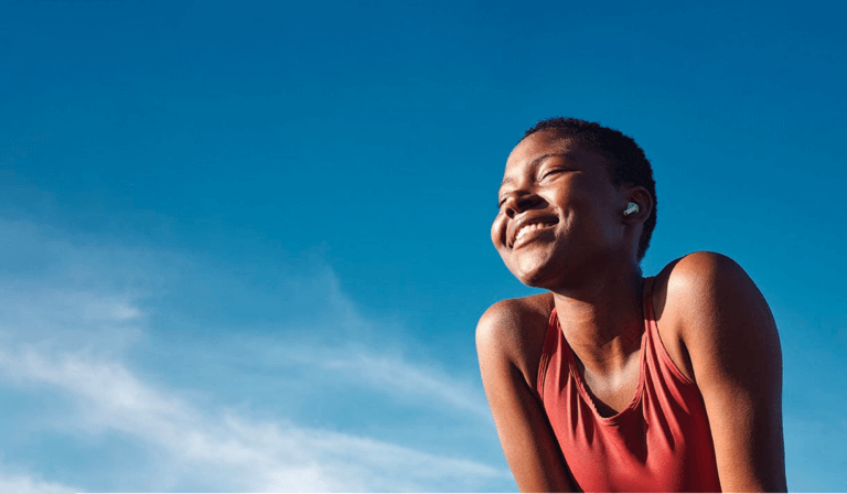 Athletic African woman after a run smiling in the sunlight.