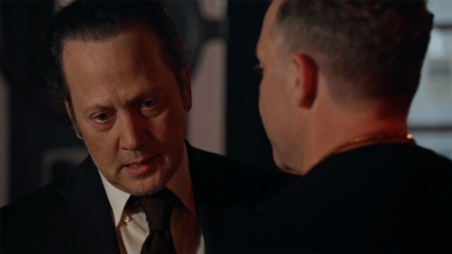 Rob Schneider in a suit looking perplexed in the movie "Dead Wrong."