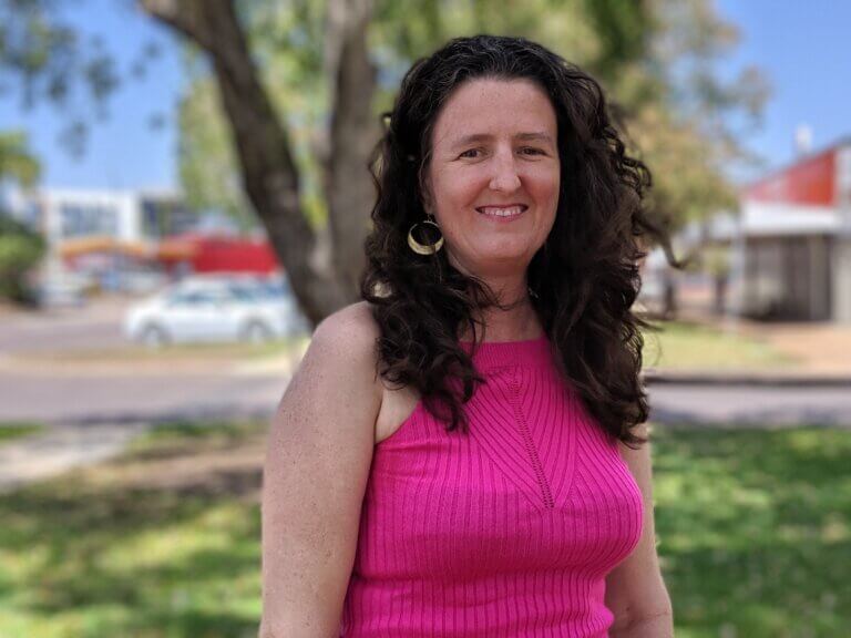 Casting Director Sarah Price smiling in a purple dress outside.