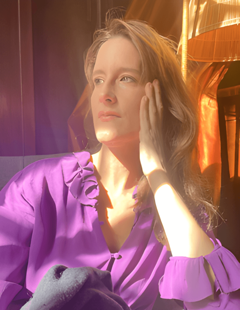 Jennifer Venditti in a purple shirt inside with the sun shining.